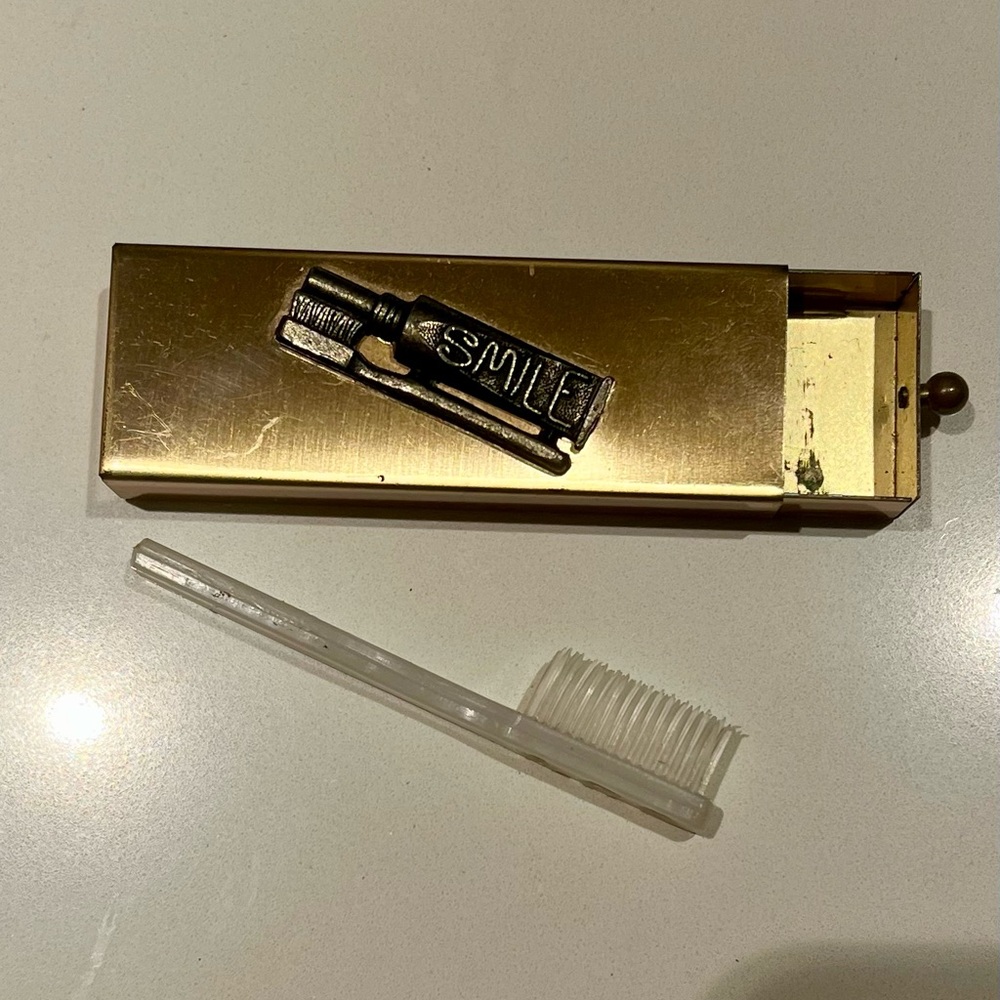 Vintage 1950s travel toothbrush case with “Smile” detail